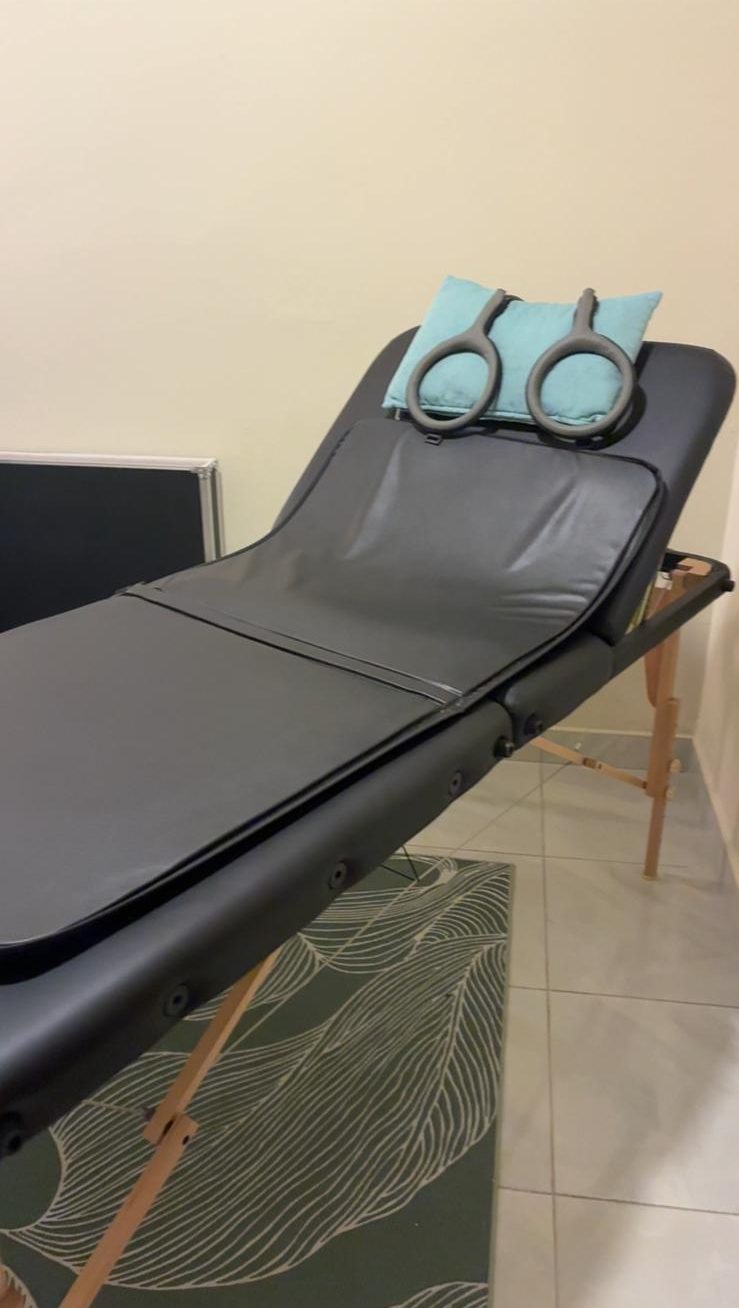 Das PEMF-System von Whealth auf einer Behandlungsliege, mit einem Kissen und zwei grauen Ringen am Kopfende.